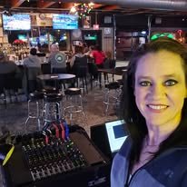 Genesis behind her mixing board at a venue karaoke night