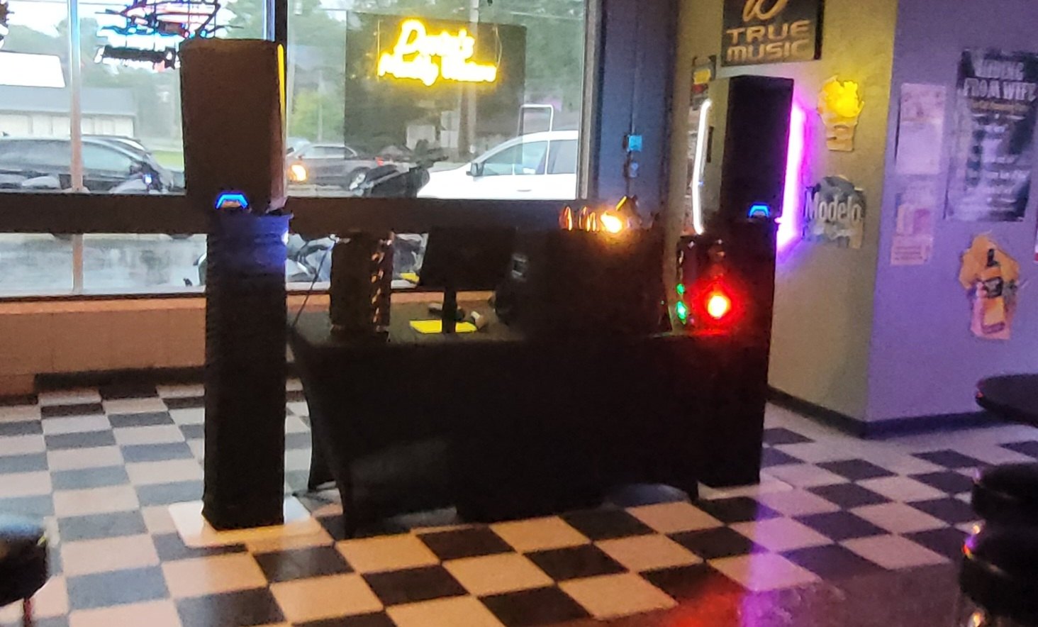 Speakers and DJ table set up inside a neighborhood bar for a karaoke night